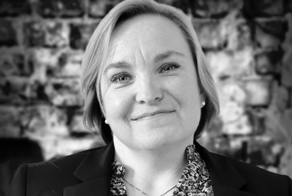 Black and white portrait of Adele Heidenreich against a brick wall