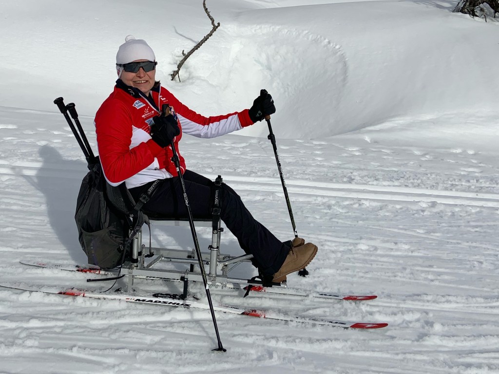 Adele Heidenreich using a sit-ski on cross-country ski trail in snowy terrain