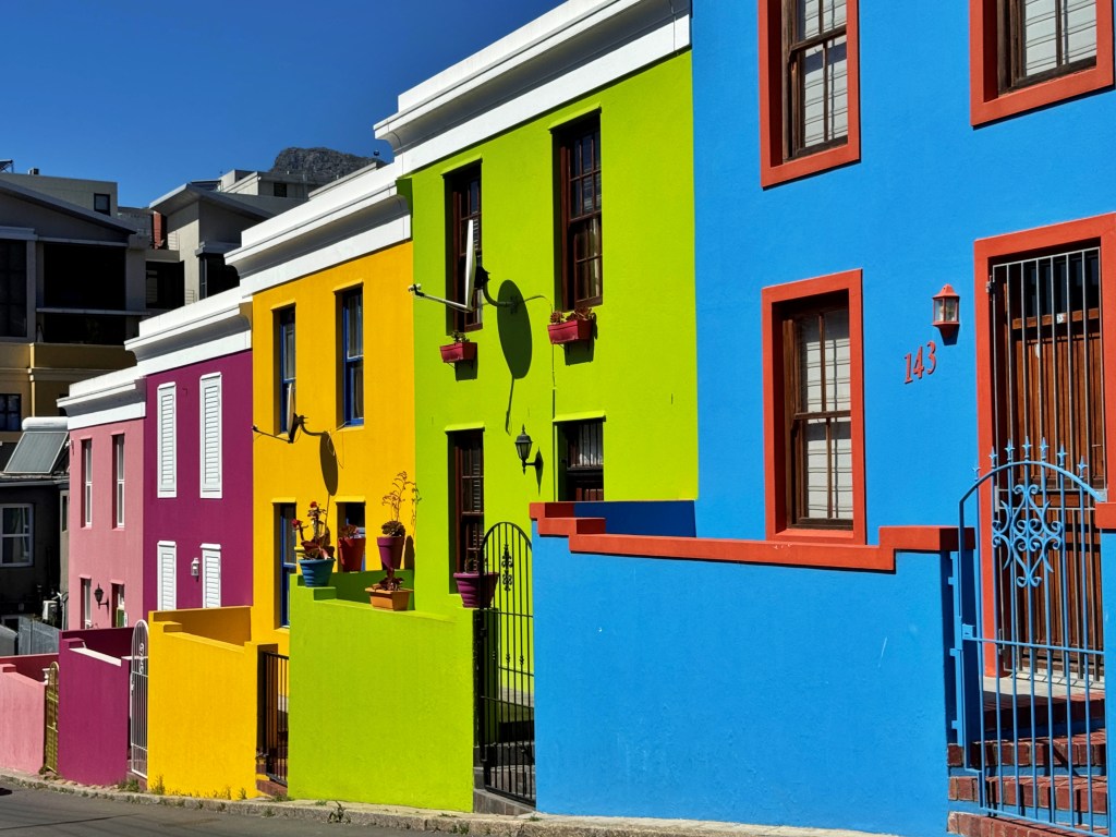 A row of vibrant, multi-colored houses in the Bo-Kaap neighborhood of Cape Town